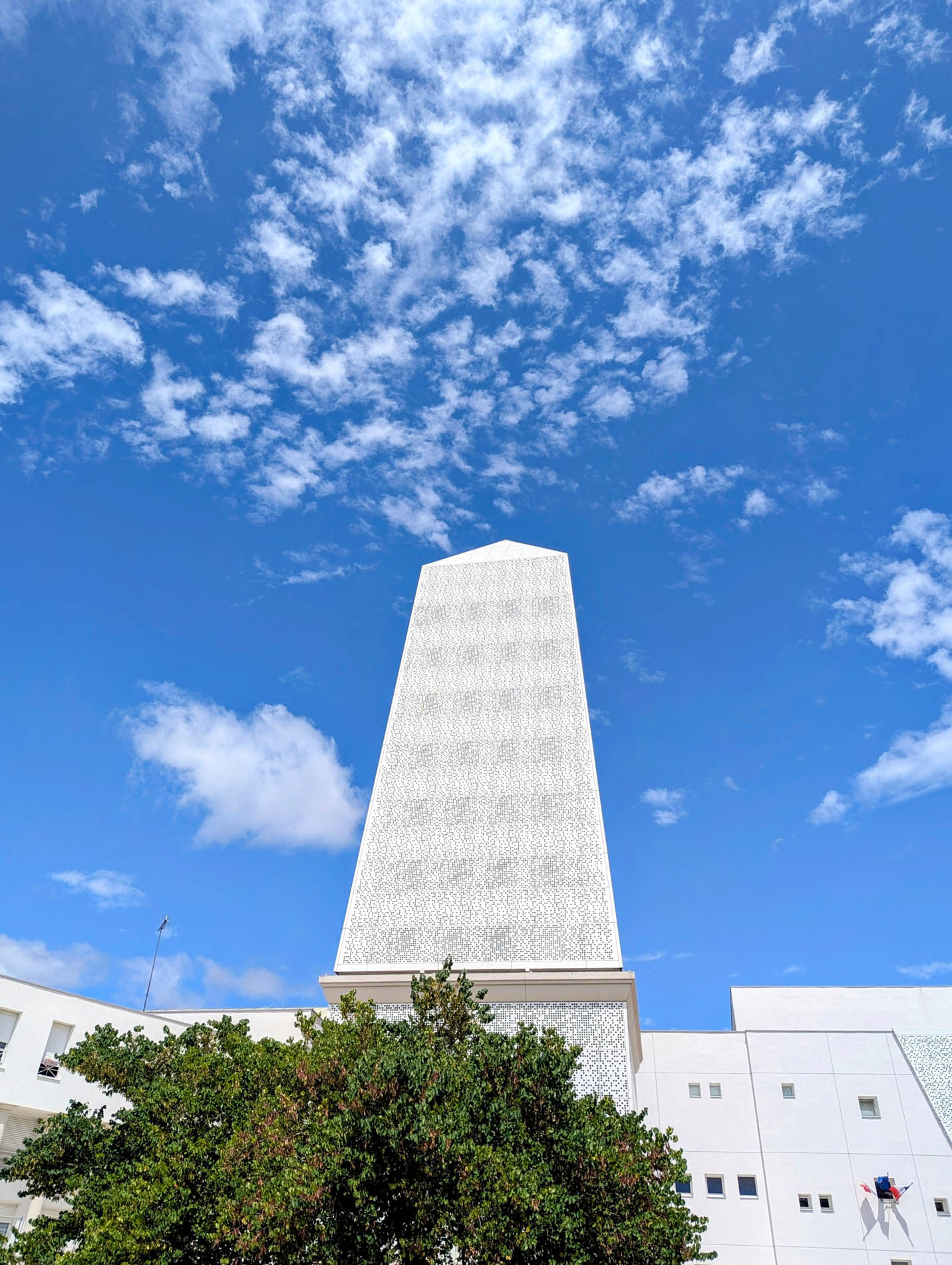 L’obélisque après la rénovation, céramique blanche sous un ciel bleu parsemé de nuages